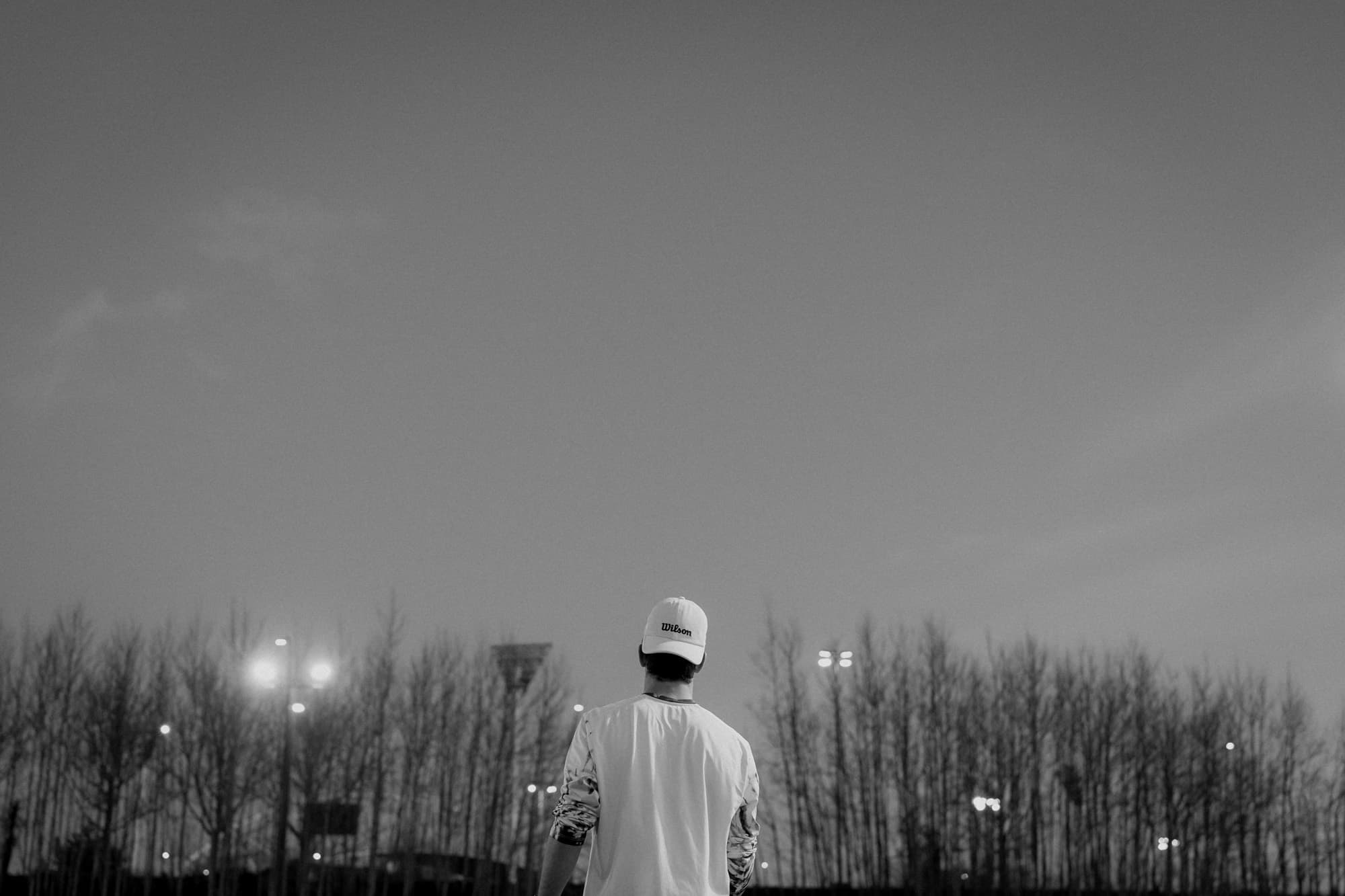 Tennis player standing on court under lights