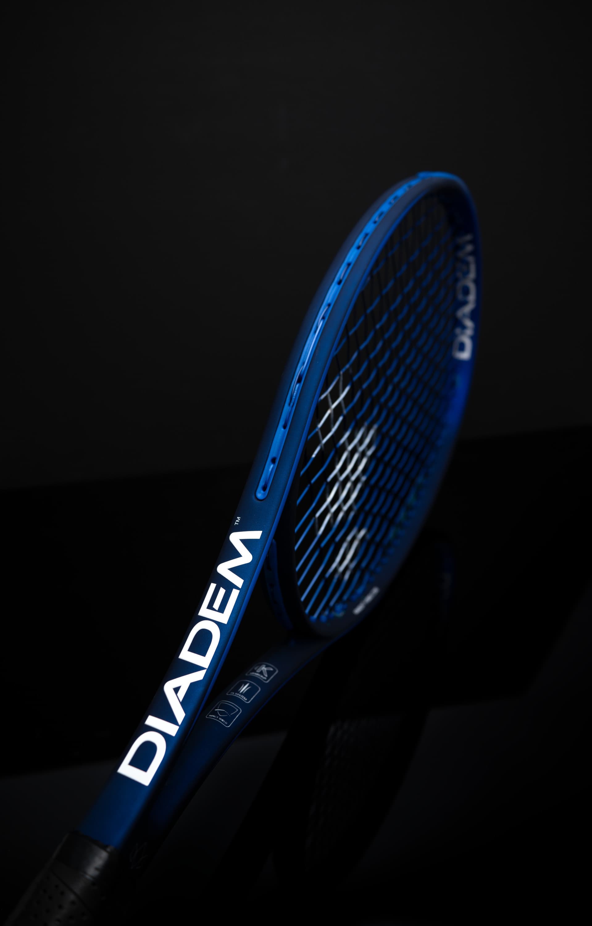 Blue Diadem Elevate tennis racquet against a dark background
